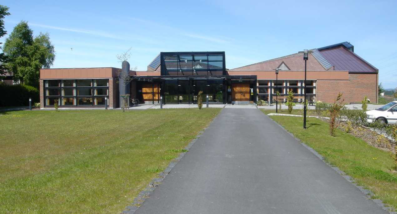 Bildet viser Tjensvoll kirke sett forfra på en flott sommerdag